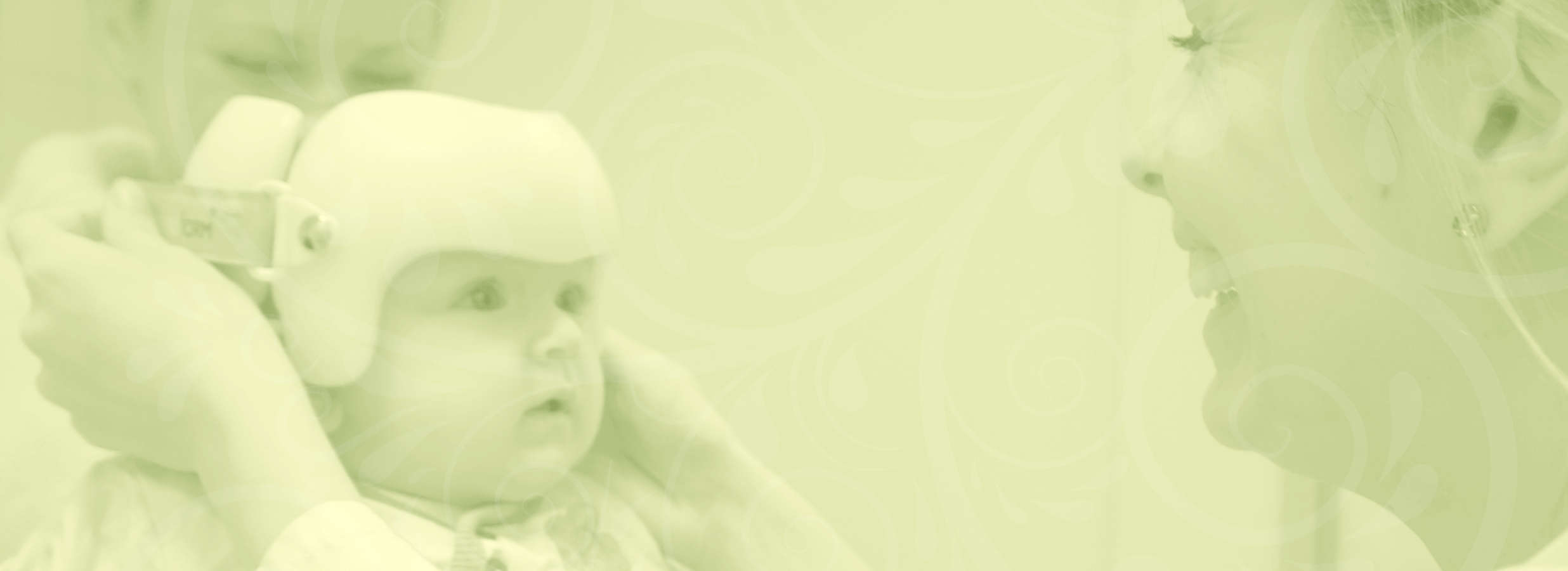 Symbolbild: Eine junge Mitarbeiterin setzt einem Baby einen therapeutischen Helm auf.